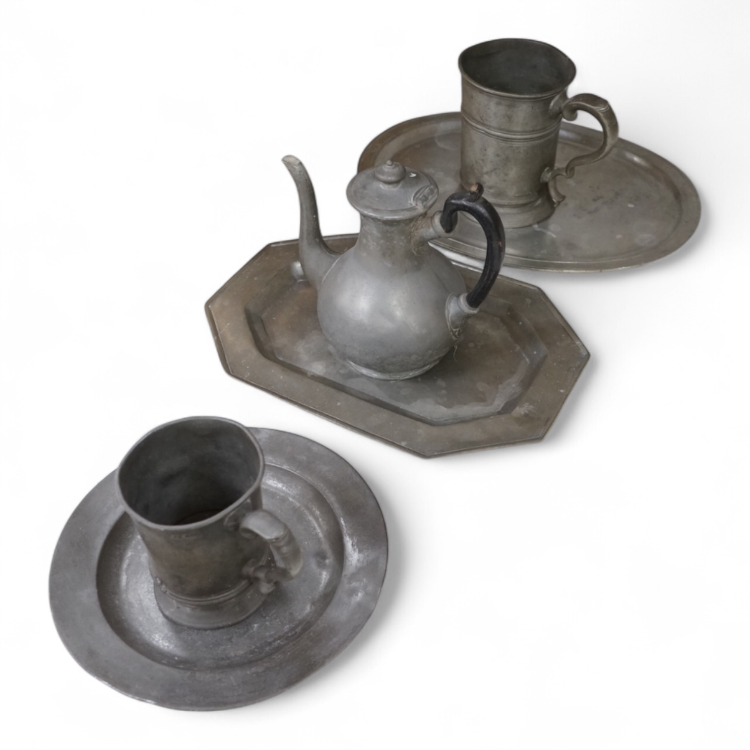 Six items of 19th century pewter, including two tankards, largest 35cm wide